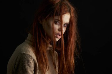 Üzgün kadın ağlıyordu. Gözlerinde morluklar vardı. Karanlık arka plan.