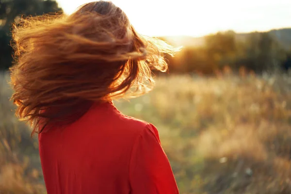 Mulher em vestido vermelho no campo andar paisagem liberdade — Fotografia de Stock