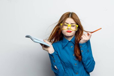 Not defteri ve kalem takan, sarı gözlüklü profesyonel bir iş kadını.