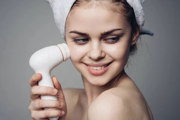 Woman with towel on head facial massager skin care hygiene — Stock Photo, Image