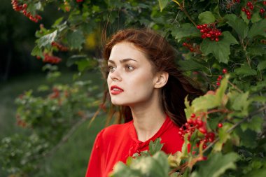 Kırsal alanda kırmızı gömlekli neşeli bir kadın.