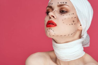 Mavi eldivenli bir kişi kırmızı dudaklı yüz yenileme ameliyatı yakın plan.