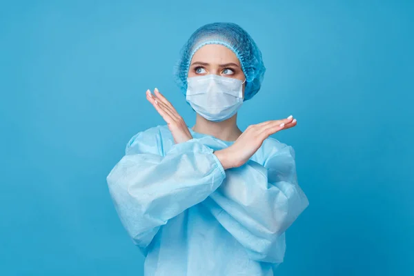 Médico en ropa protectora tratamiento hospital fondo azul — Foto de Stock