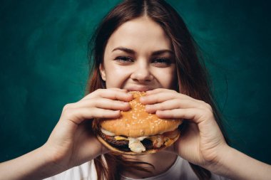 Hamburger yiyen bir kadın.