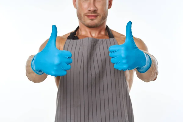 Man in blue rubber gloves in an apron gesturing with his hands — Stock Photo, Image