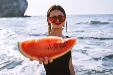 Siyah mayo giymiş neşeli güzel bir kadın karpuz moda seyahati