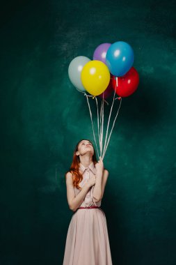 Neşeli bir kadın renkli balonlarla doğum günü eğlencesi