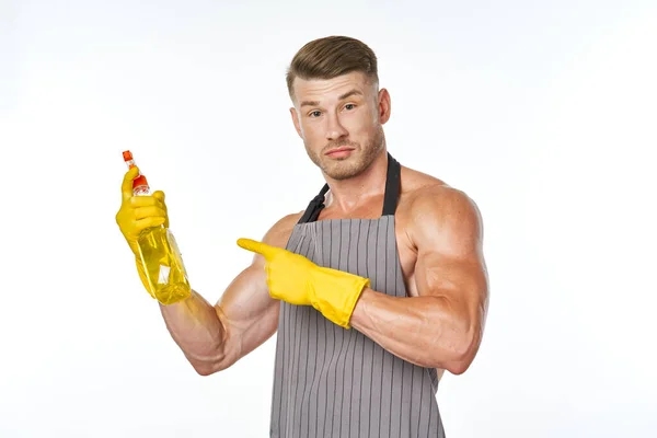 Hombre alegre en delantal detergente posando músculos — Foto de Stock