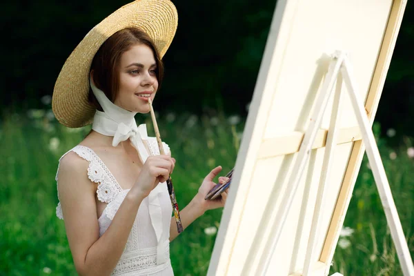 Mulher de vestido branco artista cavalete pintura natureza paisagem — Fotografia de Stock