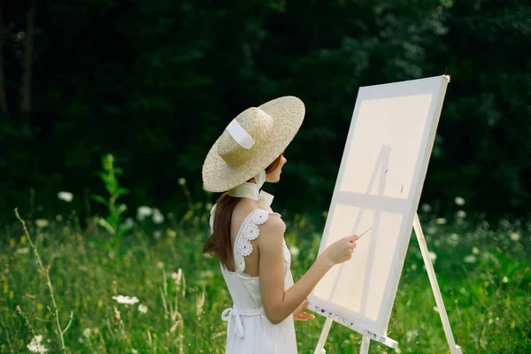 Doğada beyaz elbiseli bir kadın manzara hobisi resmi çiziyor. — Stok fotoğraf
