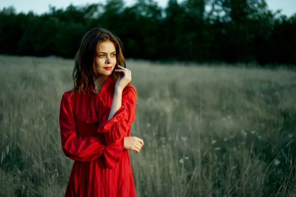 Jolie femme en robe rouge dans la nature de champ posant paysage — Photo
