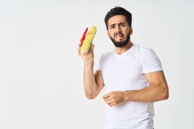 Elinde sebzelerle sakallı bir adam. Sıcak biberli mısır.