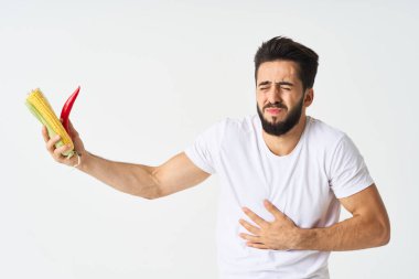 Elinde sebzelerle sakallı bir adam. Sıcak biberli mısır.