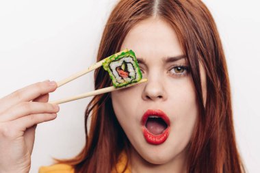 Neşeli kızıl saçlı kadın yemek çubukları suşi Japon mutfağı.