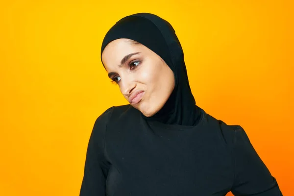 Весёлая женщина в чёрном хиджабе позирует модной рукой жестикулирует студийным стилем жизни — стоковое фото