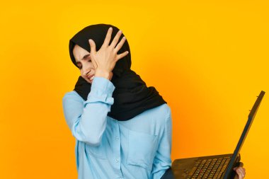 Bilgisayarlı güzel bir kadın. Teknoloji teknolojisi. Sarı arka plan.