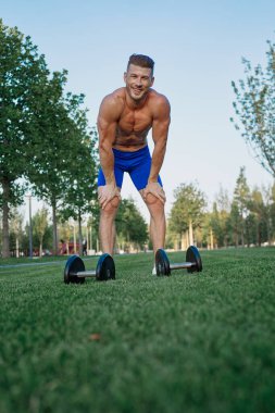 Parktaki sportif adam Crossfit egzersizi yapıyor.