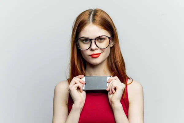 아름다운 여인 이 안경을 끼고 손에 전화기를 들고 의사소통 기술을 가지고 있다 — 스톡 사진