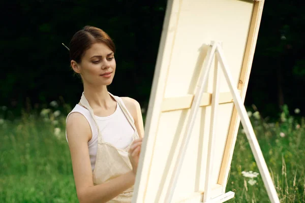 Жінка художник малює картину біля мольберта на відкритому повітрі пейзаж творчий — стокове фото