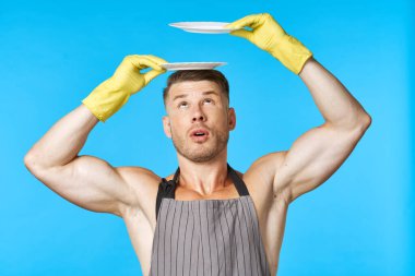 Plastik eldivenli, elinde tabakla bulaşık yıkayan bir adam.