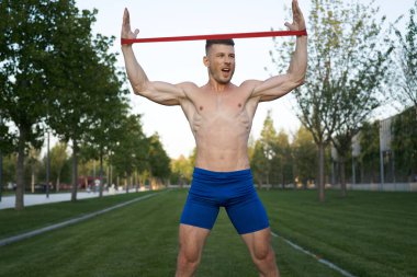 Parktaki spor salonunda mavi şortlu bir adam.
