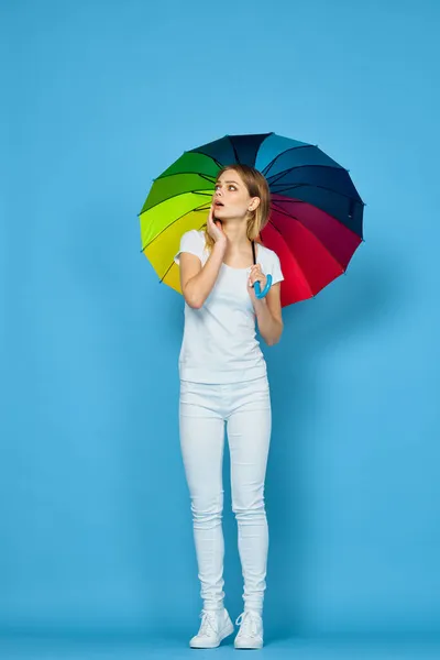 Fashionabla kvinna med paraply regnbåge färger poserar blå bakgrund — Stockfoto