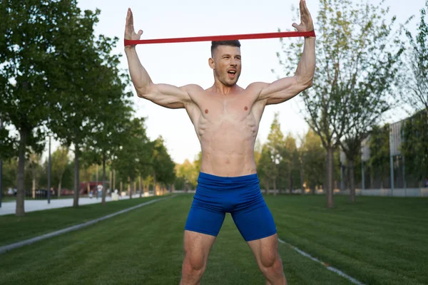 Parktaki spor salonunda mavi şortlu bir adam.