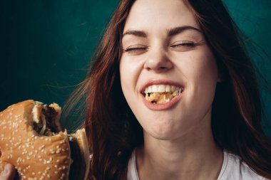 Hamburger yiyen bir kadın.