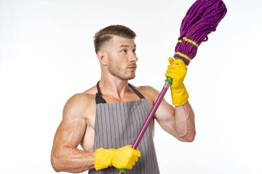 Gri önlüklü, paspas pozu veren kaslı adam.