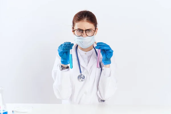 파란 장갑 약물 검사를 받고 테이블에 앉아 있는 여성 의사 — 스톡 사진