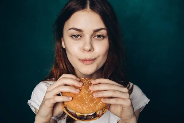 Femme gaie avec hamburger près du visage grignotage restauration rapide — Photo
