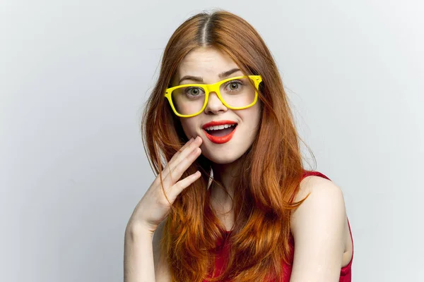Mujer bonita gafas amarillas y labios rojos moda fondo claro — Foto de Stock