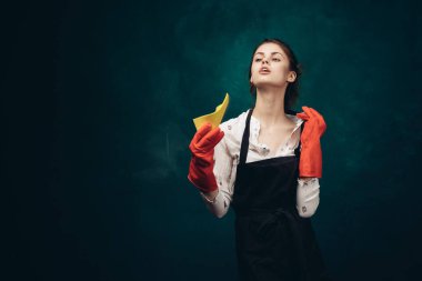 Elinde bez parçasıyla kırmızı lastik eldivenli temizlikçi kadın.