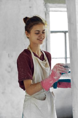 Beyaz önlüklü ev dekorasyonu yapan kadın ressam.