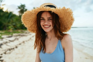 Yazın okyanus adasının yanındaki plaj şapkalı neşeli kadın
