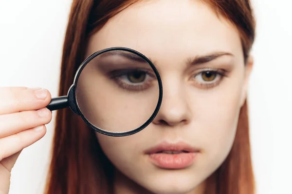 Mooie vrouw grimacing met vergrootglas in de buurt gezicht close-up — Stockfoto