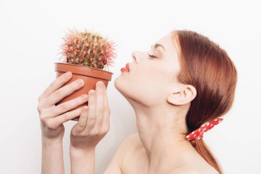 Ellerinde kaktüs olan çıplak omuzlu bir kadın.