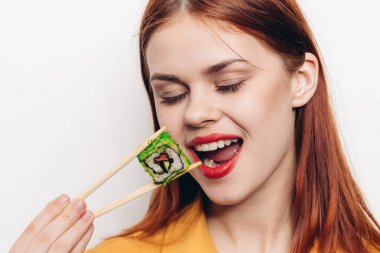 Neşeli kızıl saçlı kadın yemek çubukları suşi Japon mutfağı.