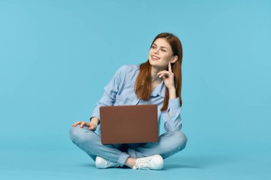 Dizüstü bilgisayarı olan kadın internet eğitimi mavi arka plan