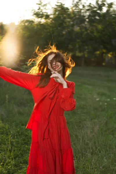 Kvinna i röd klänning poserar natur sol kul — Stockfoto