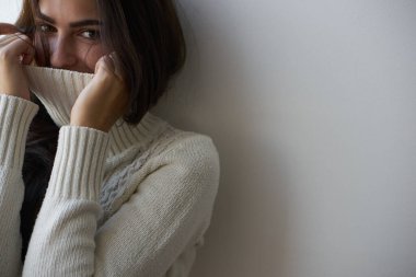 Üzgün kadın pencereden dışarı yakından bakıyor.