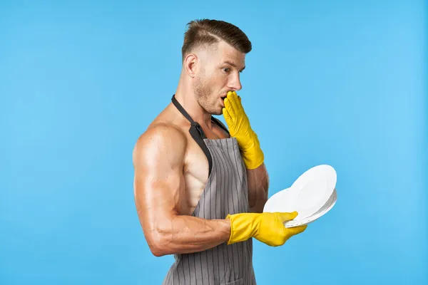 Een man in rubberen gele handschoenen met een bord in zijn handen afwas service — Stockfoto