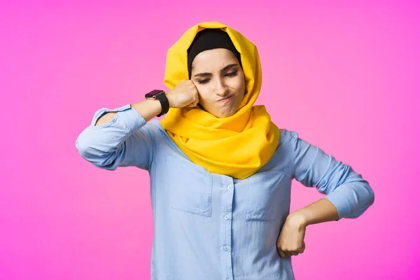 Fröhliche Frau im gelben Hijab elektronische Uhrentechnik Benutzer rosa Hintergrund — Stockfoto