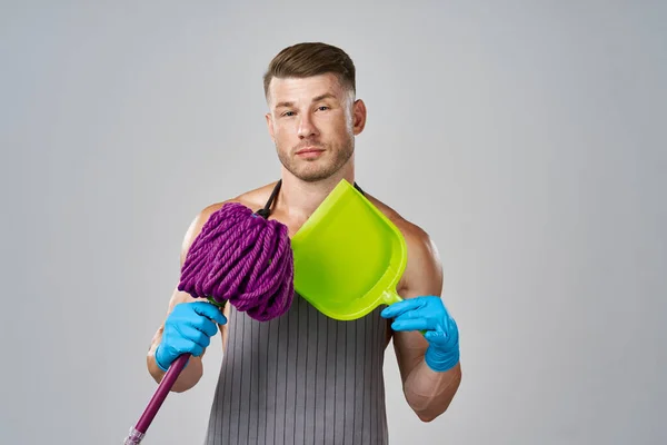 Gespierde man in schort met dweil poseren schoonmaken — Stockfoto