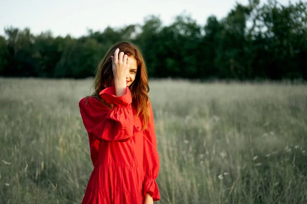 Mulher bonita em vestido vermelho no campo natureza posando paisagem — Fotografia de Stock