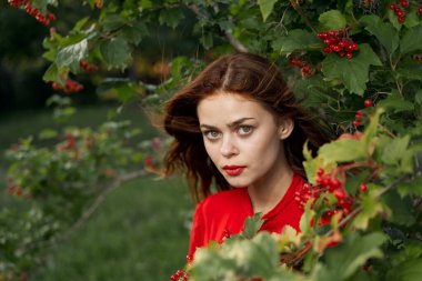 Kırsal alanda kırmızı gömlekli neşeli bir kadın.