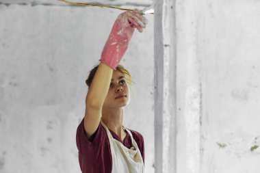 Oda dekorasyonunda fırça boyalı kadın ressam.