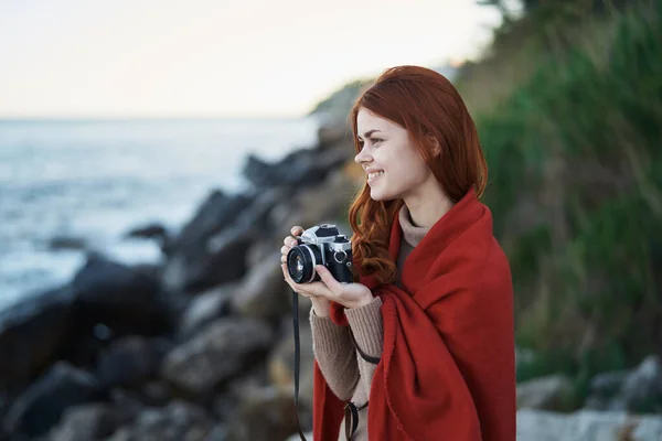 Mulher se escondendo com um cobertor na natureza com uma câmera de férias fotógrafo viagem — Fotografia de Stock