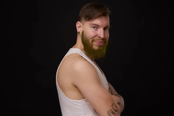 Homem barbudo elegante em uma camiseta branca com tatuagens em seus braços moda — Fotografia de Stock