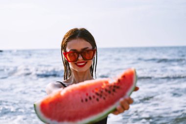 Siyah mayo giymiş neşeli güzel bir kadın karpuz moda seyahati